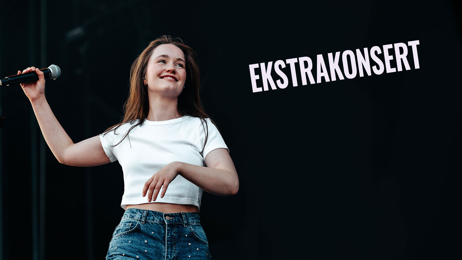Bilde av artisten Sigrid på scenen med mikrofon